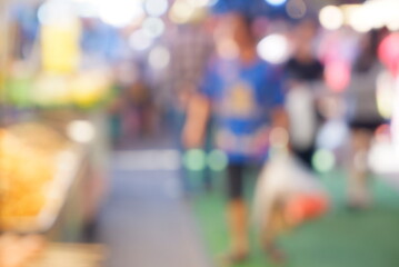 Obraz premium Blurred Night Market Lights and Moving Crowd