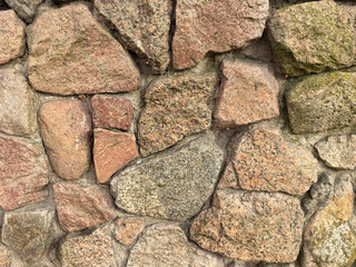 Natural stone wall showcasing diverse textures and colors in sunlight