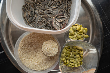 Still life with sunflower, sesame, and pumpkin seeds in glass cups