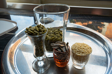 Still life with sunflower, sesame, and pumpkin seeds in glass cups
