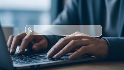 Close up of hands typing on laptop with search bar overlay