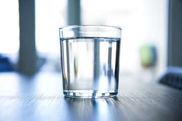 Transparent glass with water on a black table.