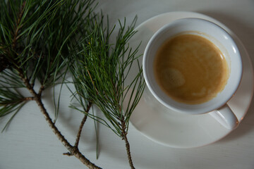 Morning cup of coffee and decor Christmas green tree with a pine cone. Ornament holiday background...