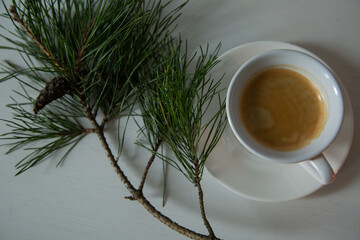 Morning cup of coffee with decor Christmas green tree with a pine cone. Ornament holiday background...