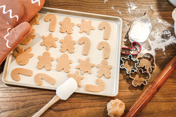 Tray of unbaked gingerbread cookies in festive Christmas shapes.