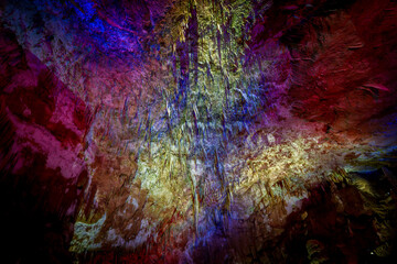 Vibrant multicolored cave wall illuminated in abstract light patterns