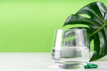 Liquid Chlorophyll Drink. Bottle and Glass with Green Chlorophyll Water, Chlorophyll powder and pills, healthy trendy vitamin beverage