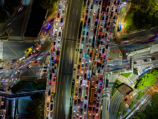 Aerial top-down view of night traffic congestion in Jakarta, Indonesia. Cars and buses fill the...
