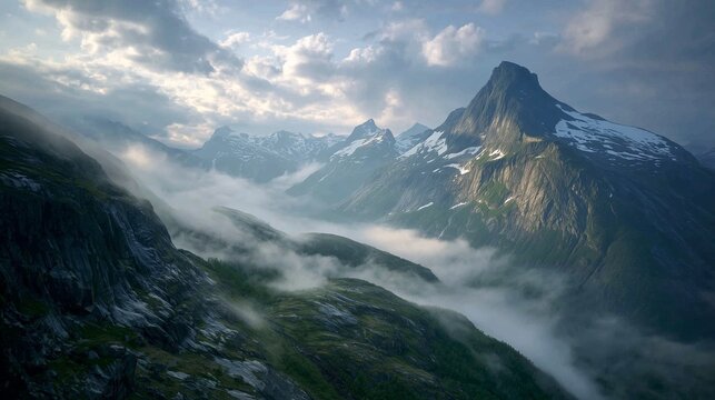 The majestic mountains rise prominently above the rolling fog, creating a breathtaking view of the natural landscape. The rugged terrain is enveloped in mist, enhancing its beauty.