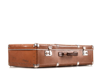 A vintage brown suitcase rests on a simple white surface, showcasing its worn leather and silver clasps. This classic piece evokes memories of travel and adventure