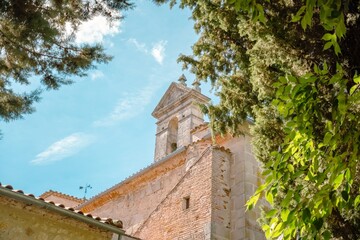 Fototapeta premium Warm Sunlight on a Traditional Church Bell Tower and Green Trees