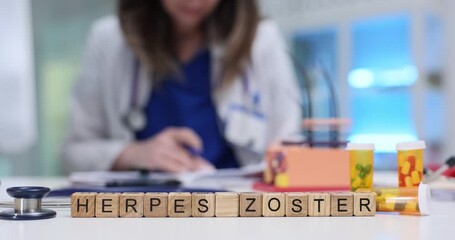 Miniature wooden cubes on desk form phrase Herpes Zoster. Experienced doctor records recommended pills and treatment plan for patient at appointment