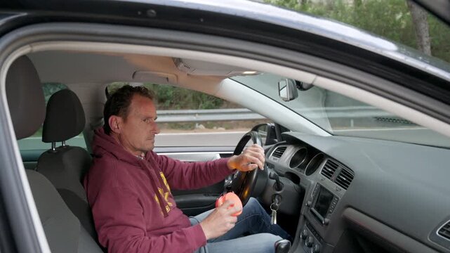 Driver taking a V16 beacon from the glove compartment and placing the flashing emergency light on the roof of his broken down car