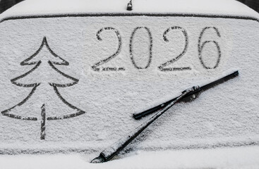 Drawing on the glass of a car covered in snow
