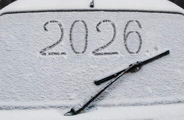 Drawing on the glass of a car covered in snow