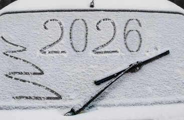 Drawing on the glass of a car covered in snow