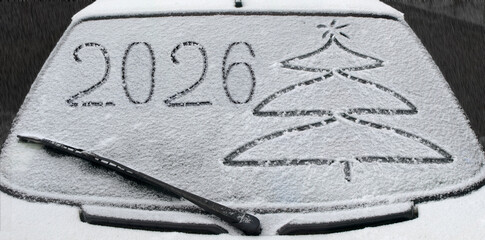 Drawing on the glass of a car covered in snow