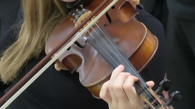 Musician Playing Violin ; A young violinist performs a classical composition on the violin