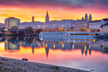 Linz, Austria. Cityscape image of riverside Linz, Austria at autumn sunrise with reflection of the city lights in Danube River.