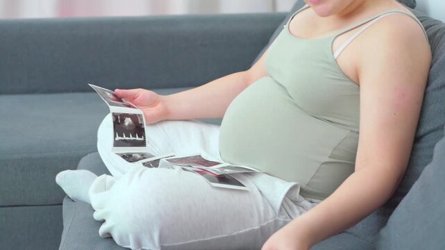 Pregnant woman sitting on a couch using her smartphone in a relaxed home setting. A calm everyday moment highlighting modern maternity lifestyle, comfort, and digital communication during pregnancy. S