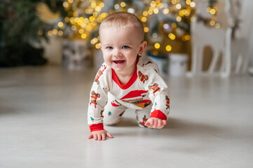 A one-year-old baby crawls on all fours, dressed in a New Year's outfit, crawling around a New Year's-decorated room, smiling. New Year and Christmas. Parenting. Family