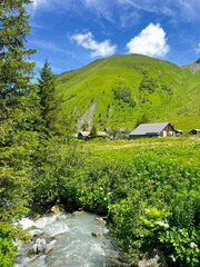 Chalet in the mountains near a rushing stream in July 