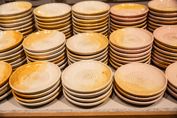 A colorful display of handmade ceramic rubbing plates at a market