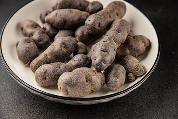 Purple potatoes raw fruit blue potatoe vegetable dish fresh gourmet food background on the table rustic food top view copy space keto and paleo diet vegan and vegetarian food