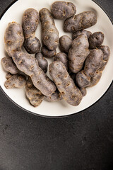 Purple potatoes raw fruit blue potatoe vegetable dish fresh gourmet food background on the table rustic food top view copy space keto and paleo diet vegan and vegetarian food