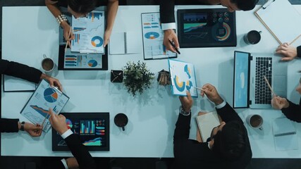 Top down aerial view of business people discussing about financial strategy on table with document and tablet display investment statistic at meeting. Diverse team brainstorm about plan. Directorate. - Powered by Adobe