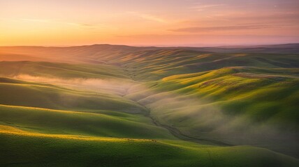 Obraz premium Rolling green hills of tuscany landscape at sunrise with soft mist settling in the valleys under a colorful sky