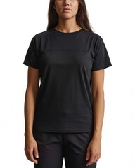 Fototapeta premium Woman wearing a plain black short sleeve tshirt and dark pants standing against a white background, studio shot