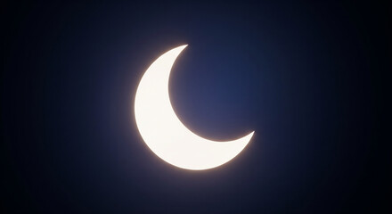 Partial solar eclipse showing a bright crescent shape of the sun against the dark deep space sky, representing an astronomical phenomenon.