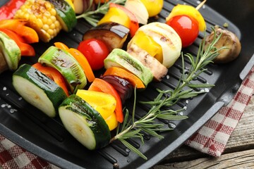 Grill pan with tasty vegetables on wooden table, closeup