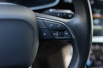 Volume button of car radio on steering wheel. Turns up the volume of the music. Buttons on the steering wheel to accept or reject calls from the phone. Hands free and media control buttons