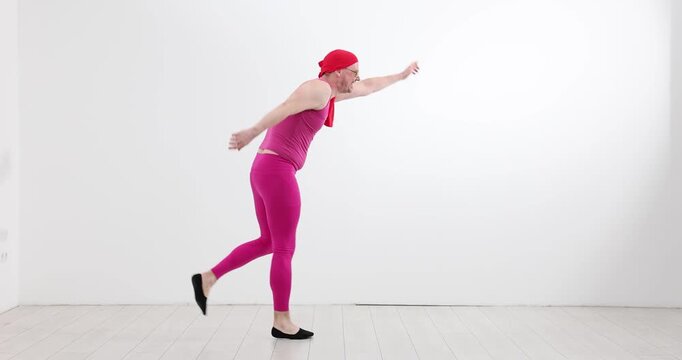 Man in bright pink outfit stretches arms and legs in running pose. Funny performer imitates running in same place being energetic slow motion