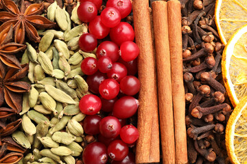 Different spices, dry orange slices and cranberries for mulled wine as background, top view