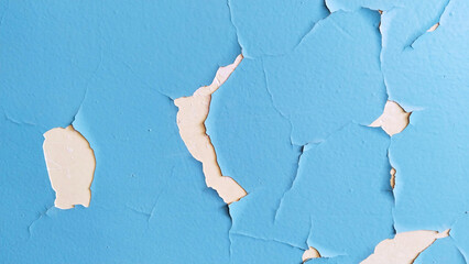 Old cracked blue paint on wall. Cleaning. Peeling off painted background. House repair. Plaster. Peeled domestic room. Poverty. conservation. Wallpaper. Residential building. Textured effect. Hole.