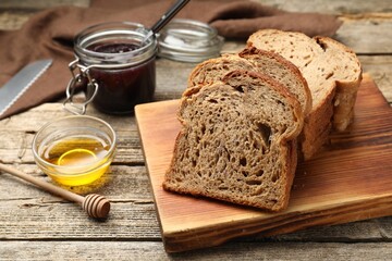Bread slices with honey and jam on wooden table