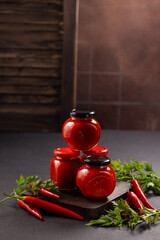 Homemade hot chili sauce jars on dark background