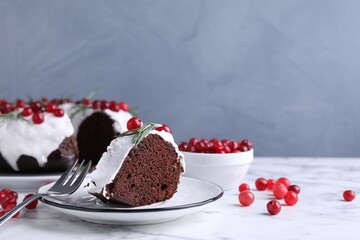 Tasty Christmas cake with cranberries and rosemary served on white marble table against light background, closeup. Space for text