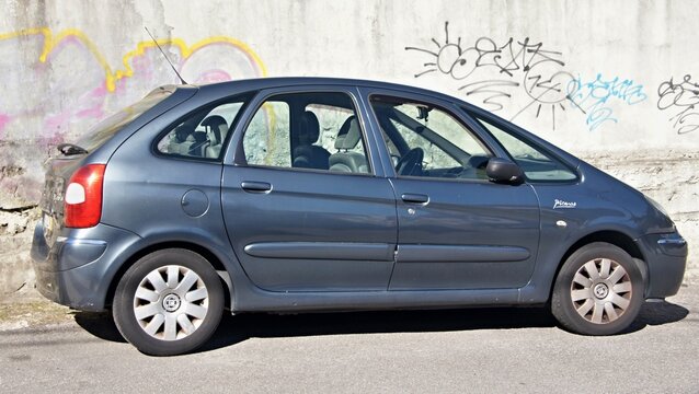 Parked Citro&euml;n Xsara Picasso car by graffiti wall