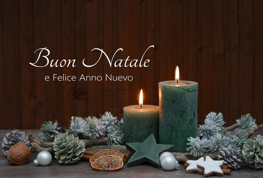 Candele verdi accese con decorazioni natalizie e rami di abete davanti a una tavola di legno. Sul legno è scritto il saluto "Buon Natale e Felice Anno Nuovo".