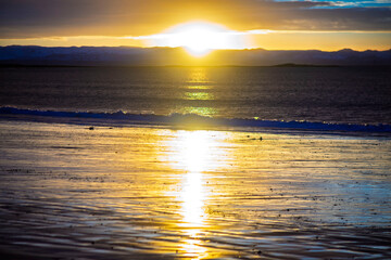 Golden sunset reflection on beach in Akranes Iceland
