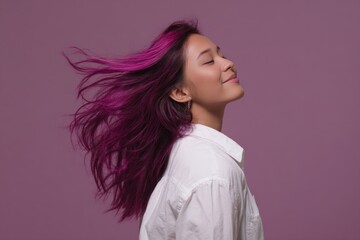 Confident asian young woman with vibrant purple hair on pink background