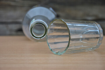 on the table there is an empty bottle and an empty overturned glass. alcohol consumption concept