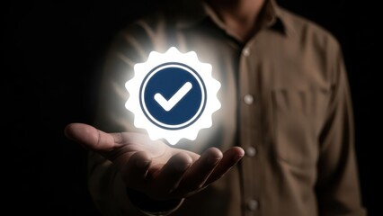 Man holding glowing verified badge with checkmark symbol in his palm against dark background