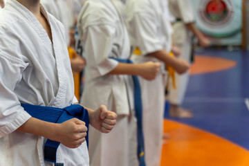 Children in white uniforms with blue and yellow belts