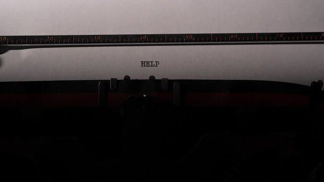 Vintage typewriter creating the word help on a blank sheet of paper, symbolizing communication, distress call, desperation, and a plea for assistance or support