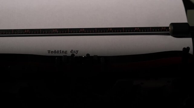 Vintage typewriter producing text with wedding day typed on a sheet of white paper, symbolizing love, marriage, and timeless messages for special occasions